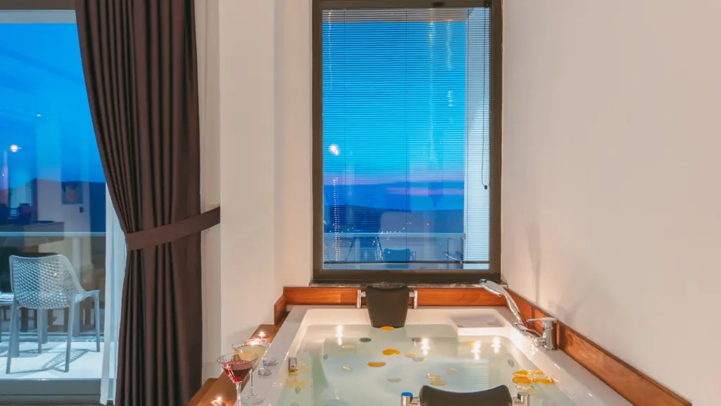 Illustrative bathtub beside a window overlooking the sea